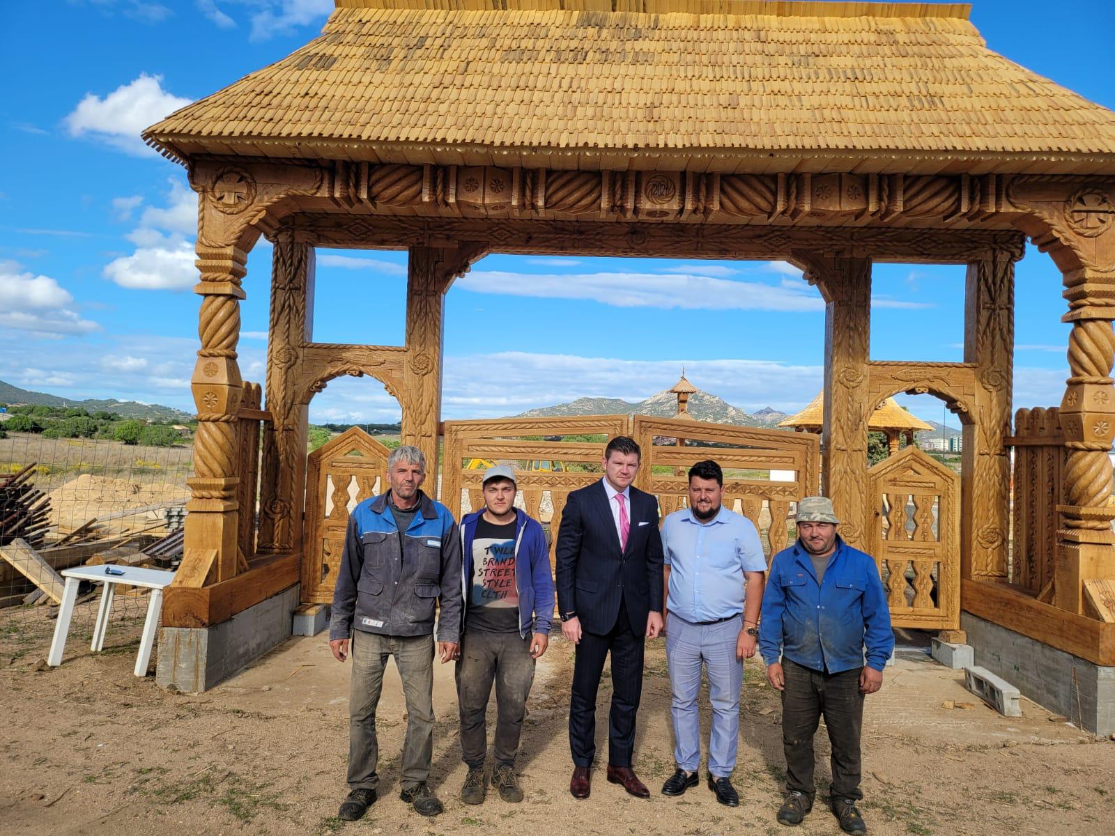 Anton with a group at the carved wooden gateway during the construction of the church in Olbia, Sardinia