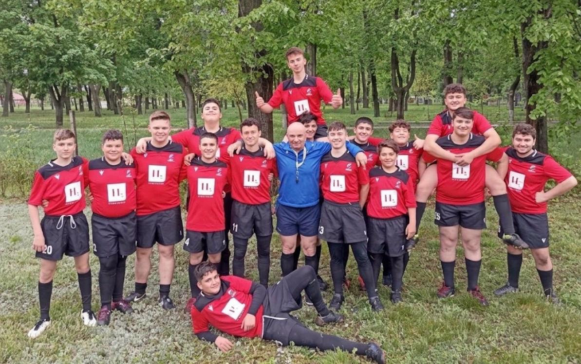 A young rugby team in red shirts gathered for a photograph
